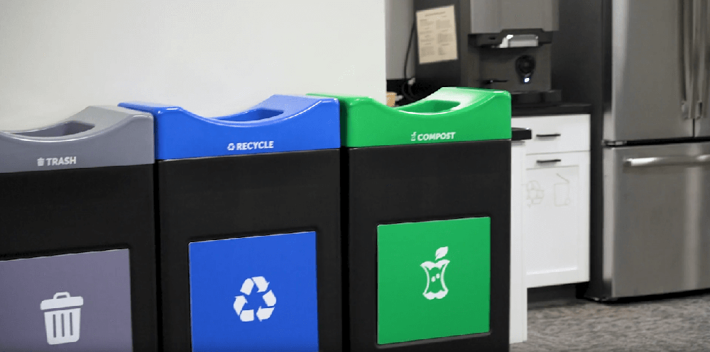 Indoor waste station featuring trash, recycling, and compost bins with color-coded lids for organized waste separation.